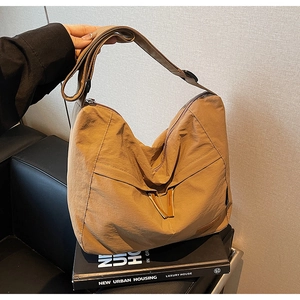 Detail of earth-tone canvas tote bag featuring adjustable wide strap and soft texture