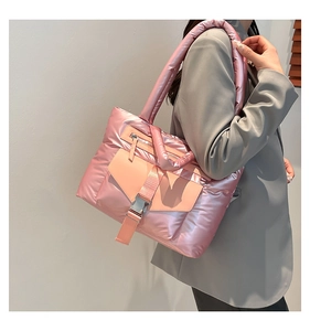 Dettaglio della borsa in nylon trapuntato rosa con tracolla imbottita e finitura lucida