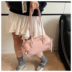 Dettaglio borsa bowling in pelle verniciata rosa con fiocco decorativo e occhielli