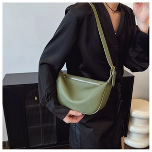 Detail of avocado green crescent shoulder bag in lychee textured leather with silver zipper