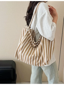Stylish striped canvas tote bag featuring large capacity and a convenient front pocket