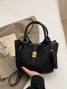 Black textured leather tote bag with metal twist lock and cute dog charm for women