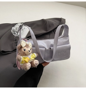 Macro shot of light purple PU leather bag texture with MURETI lettering and mini bear