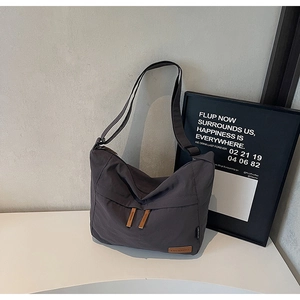 Detail of waterproof grey canvas tote showing leather brand tag and textured fabric