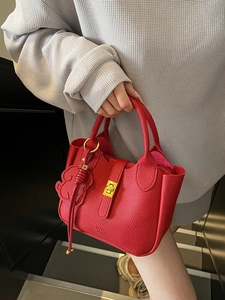 Minimalist red leather tote bag with gold rotary lock and leather dog charm decoration
