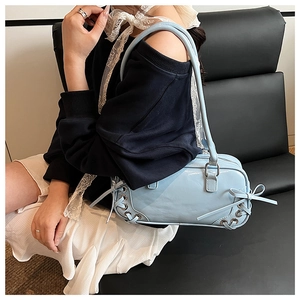 Dettaglio borsa sottobraccio in pelle azzurra con esclusivo design con lacci