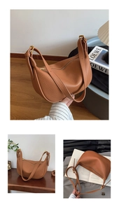 Detail of brown textured leather crescent bag with gold-tone hardware and adjustable strap