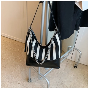 Close-up of black and white vertical striped fabric hobo bag with silver metal chain detail