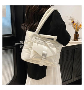 Dettaglio della borsa trapuntata in nylon bianco con fibbia e tasca superiore con zip