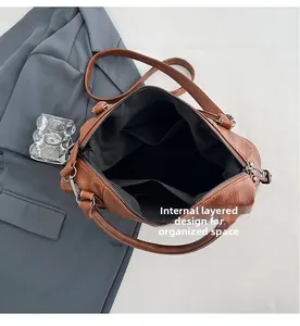 Internal view of brown leather bag showing black lining, pockets, and layered design