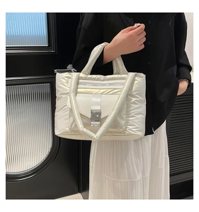Dettaglio della borsa tote in nylon trapuntato bianco con tasca a patta e fibbie lucide