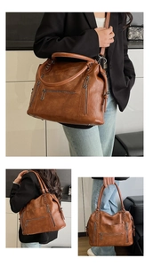 Close-up of brown vintage leather tote bag with multiple decorative silver zippers