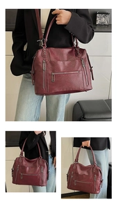 Detail of vintage burgundy tote bag with silver rivets and multiple zipper pockets