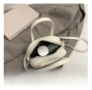 Vue intérieure du sac bandoulière rond blanc montrant la capacité quotidienne