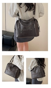 Detail of dark brown tote bag with multi-zipper pockets and adjustable shoulder strap