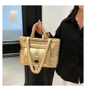 Dettaglio della borsa tote in nylon dorato trapuntato con finitura metallica e fibbia