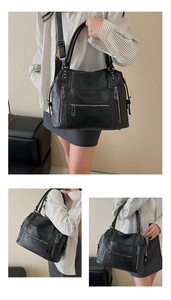 Detail of vintage black large tote bag showing textured leather and multi-zipper pockets