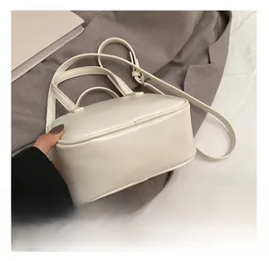 Détail du sac bandoulière blanc minimaliste avec finition lisse et poignées rondes