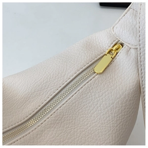 Detailed macro view of white lychee pattern leather texture and golden metal zipper hardware