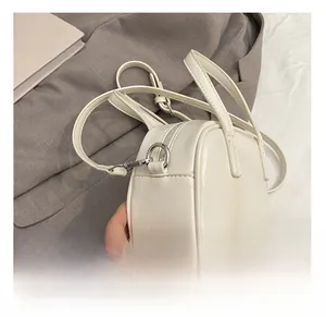Détail des coutures de qualité et des finitions métalliques argentées sur le sac beige
