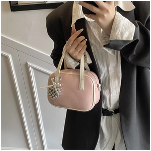 Gros plan du sac à main rose brillant avec breloque cœur et garnitures blanches