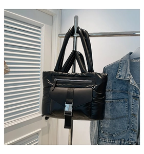 Dettaglio della borsa tote trapuntata in nylon nero con fibbia in metallo e zip frontale
