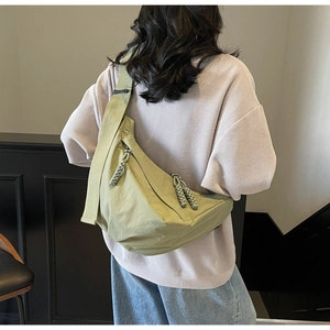 Detail of light green nylon crescent bag with durable woven rope zipper pullers
