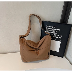 Détail d'un sac cabas en nylon marron avec poche zippée et bandoulière ajustable