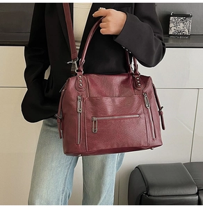 Detail view of wine red PU leather tote bag with three functional front zipper pockets
