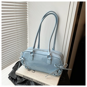 Detailed view of the light blue glossy bag featuring side lacing and a bow accent