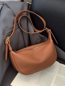 Brown textured leather half-moon shoulder bag with adjustable strap and gold zipper closure