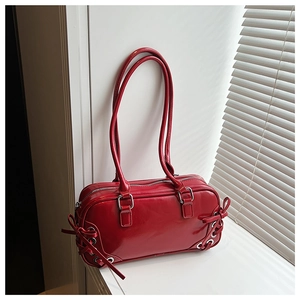 Dettaglio della borsa sottobraccio in vernice rossa con fibbie argentate eleganti