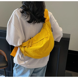 Rear view of yellow nylon crescent bag featuring double zippers and wide shoulder strap