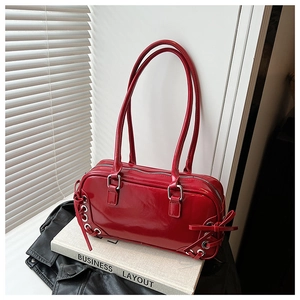 Detail of red patent leather shoulder bag with metallic eyelets and silver zipper