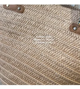 Detail of woven straw texture with brown leather reinforcement and vintage rivets
