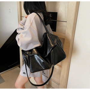 Large black tote bag in glossy wrinkled faux leather with metallic clasp for daily use