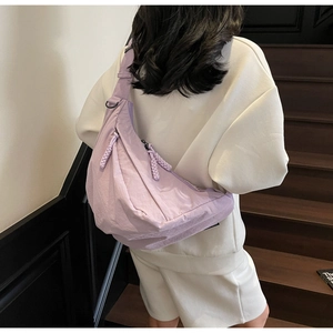 Detail of light purple nylon crescent bag with adjustable strap and knotted zipper pull