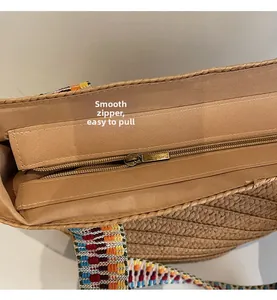 Detail of a woven straw bag with a smooth brown fabric lining and a metallic zipper closure