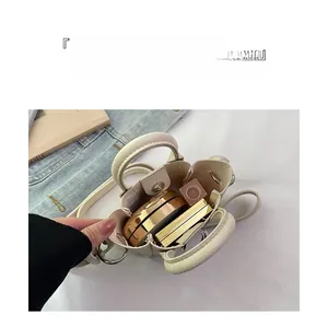 Dettaglio della mini borsa a tracolla panna che mostra lo spazio interno per cosmetici
