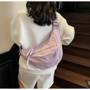 Close-up of lavender nylon crescent bag featuring braided zipper pull and adjustable strap