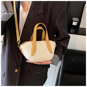 Détail du sac à main en cuir gaufré crocodile avec poignées jaunes et bandoulière réglable