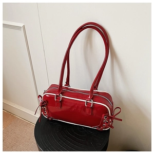 Detail of red patent leather bowling bag with side ribbon bows and silver hardware