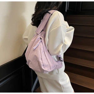 Back view of model wearing a lavender nylon dumpling bag on a stylish staircase