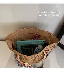 Spacious interior of beige woven straw tote bag with colorful strap and inner zipper pocket