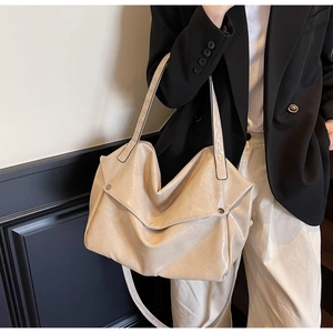 Detail of soft cream vintage oil wax leather tote bag with metallic rivet accents