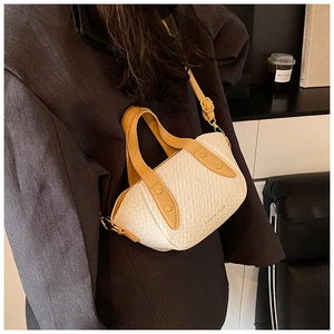 Détail du sac à main blanc crème avec lanières brunes et rivets dorés