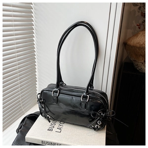Detail view of glossy black Y2K style bowling bag featuring chic ribbon side bows