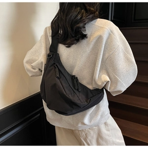 Large black nylon dumpling bag shown on a model for a stylish casual commuter look