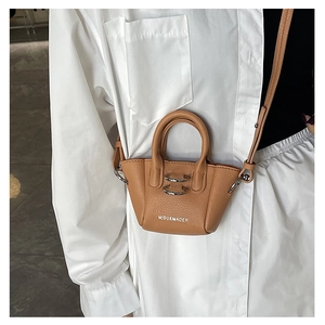 Dettaglio mini borsa in pelle martellata color cuoio con anelli in metallo argento