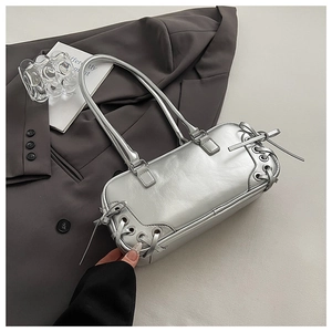 Close-up of metallic silver handbag featuring stylish criss-cross lace-up side details